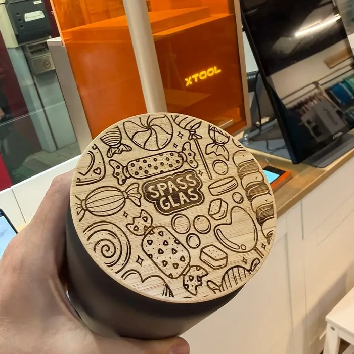 Bambus-Deckel eines Trinkbechers mit Süßigkeiten-Motiven und Schriftzug Spassglas, graviert mit dem xTool F1 Ultra